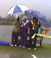Officials huddle under umbrellas